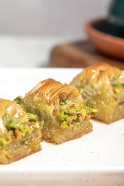 Cimcik baklava. Akdeniz mutfağı aromalı. Kırsal masada Türk kahvesi, ramazan ya da bayram tatlıları konsepti olan şam fıstıklı baklava. Kapat.