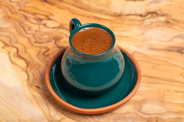 Turkish coffee. Traditional Turkish cuisine flavors. Freshly brewed Turkish coffee on a wooden background. This coffee is very famous in middle east and turkey. Close up