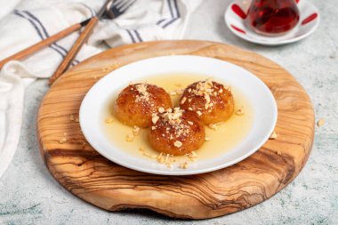 Sütlü Kemalpasa tatlısı. Türk ve Orta Doğu mutfağı tatlısı. Ramazan yemeği. Tahta servis tahtasındaki Kemalpasa tatlısı.