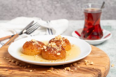 Sütlü Kemalpasa tatlısı. Türk ve Orta Doğu mutfağı tatlısı. Ramazan yemeği. Tahta servis tahtasındaki Kemalpasa tatlısı.