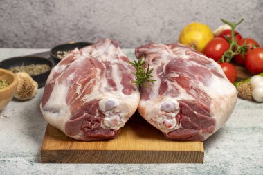 Kuzu budu kasap ürünleri. Çiğ kuzu bacağı eti ve taş zeminde kemikler.