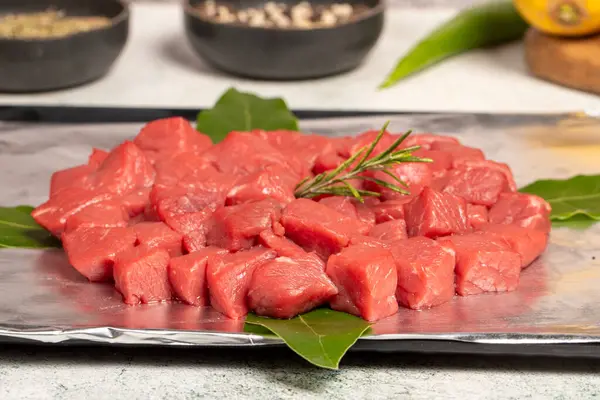 Beef cubed meat. Butcher products. Chopped raw beef on stone background