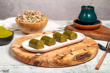 Ahşap arka planda fıstıklı baklava. Türk mutfağı lezzetleri. Ramazan tatlısı. Yerel adı sarma veya durum baklava