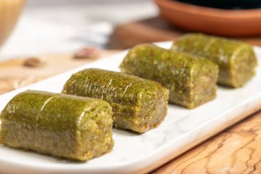 Ahşap arka planda fıstıklı baklava. Türk mutfağı lezzetleri. Ramazan tatlısı. Yerel adı sarma veya durum baklava