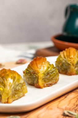 Ahşap arka planda fıstıklı midye baklavası. Türk mutfağı lezzetleri. Ramazan tatlısı. yerel adı Midye Baklava