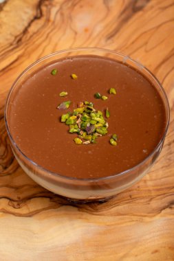 Çikolatalı puding. Süslü tatlı, kremalı ve çikolatalı puding, ahşap servis tahtasında.