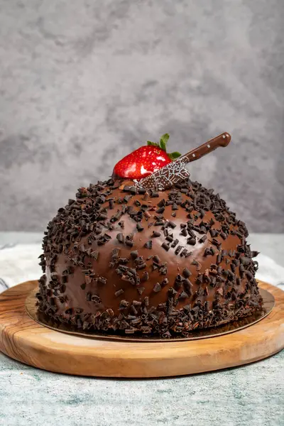 Chocolate and strawberry cake. Chocolate and fruit birthday cake on wooden serving board