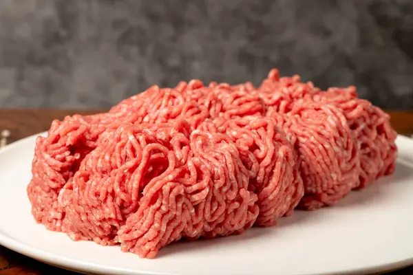 Ground beef. Butcher products. Fresh minced meat on dark background