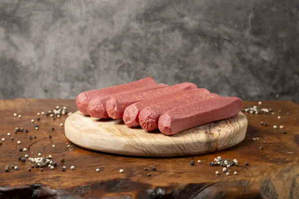 Raw sausage. Butcher products. Sausages made from uncooked beef on a dark background