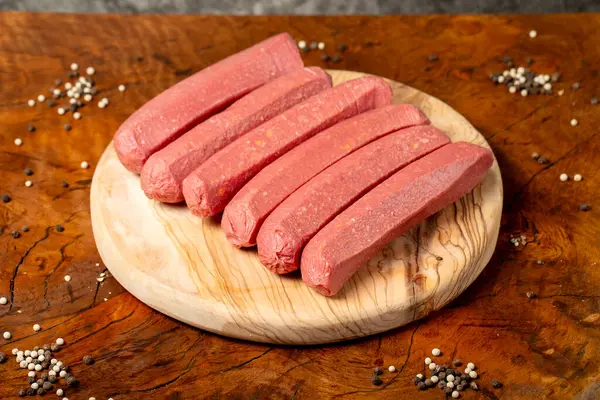 Raw sausage. Butcher products. Sausages made from uncooked beef on a dark background