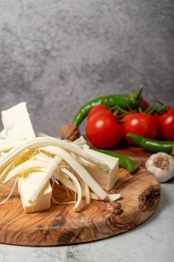 İp peyniri. Tahta servis tahtasındaki tel peynir taneleri.