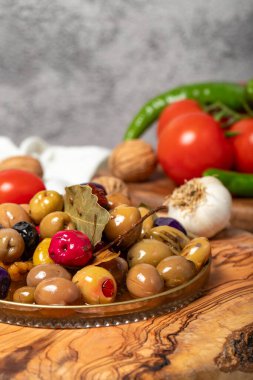 Karışık zeytin. Tahta servis tahtasında çeşitli zeytinlerle hazırlanmış özel zeytinler. Kapat.