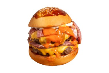 Duble Hamburger beyaz arka planda izole. Çedar peyniri, karamelize soğan, biftek ve özel sosla. Servis masasında iki köfteli hamburger.