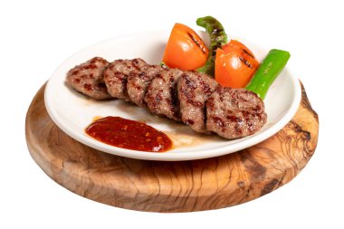 Beyaz arka planda ızgara köfteler. Domates, biber, aperatif ve özel sosla. Tabakta Türk köftesi