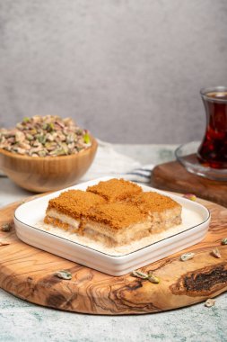 Bisküvi ve sütle birlikte baklava. Tahta servis tahtasının üzerinde bisküvi olan soğuk baklava. Türk mutfağının ünlü yemekleri