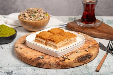 Bisküvi ve sütle birlikte baklava. Tahta servis tahtasının üzerinde bisküvi olan soğuk baklava. Türk mutfağının ünlü yemekleri