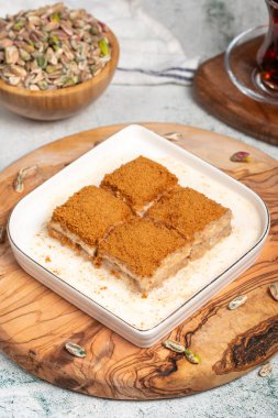 Bisküvi ve sütle birlikte baklava. Tahta servis tahtasının üzerinde bisküvi olan soğuk baklava. Türk mutfağının ünlü yemekleri