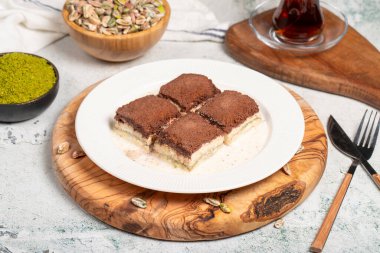 Koyu çikolata ve süt baklavası. Tahta servis tahtasına çikolata konmuş soğuk baklava. Türk mutfağının ünlü yemekleri