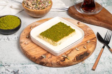 Fıstıklı ve sütlü Kadayif tatlısı. Soğuk kadayif çikolatalı servis tahtası. Türk mutfağının ünlü yemekleri