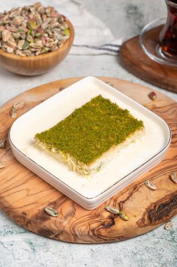 Fıstıklı ve sütlü Kadayif tatlısı. Soğuk kadayif çikolatalı servis tahtası. Türk mutfağının ünlü yemekleri