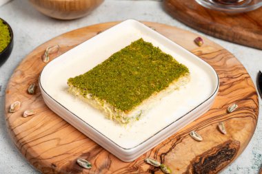 Fıstıklı ve sütlü Kadayif tatlısı. Soğuk kadayif çikolatalı servis tahtası. Türk mutfağının ünlü yemekleri