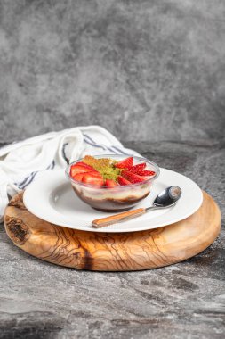 Çilekli manolya tatlısı. Tahta servis tahtasında çilekli puding. Türk mutfağının ünlü yemekleri