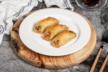 Ceviz baklavası. Ahşap servis tahtasına ceviz ve krema konmuş Baklava. Yerel adı cevizli kelebek baklava