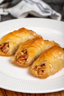 Ceviz baklavası. Ahşap servis tahtasına ceviz ve krema konmuş Baklava. Yerel adı cevizli kelebek baklava