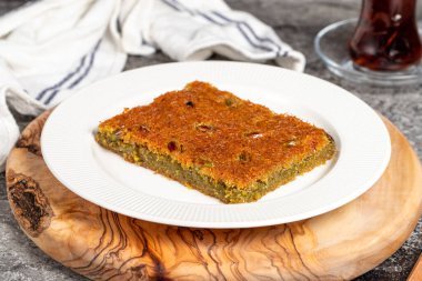 Şerbetli Kadayif tatlısı. Geleneksel Türk mutfağı tatlısı. Ahşap servis tahtasında fıstıklı Kadayif.