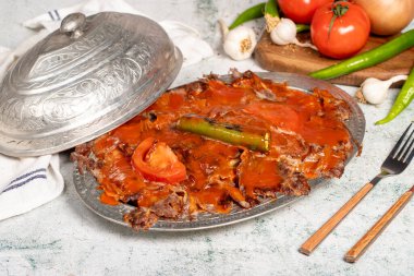 Iskender kebab. Traditional Turkish cuisine taste. Cooked iskender kebab with sauce and butter on a gray background. Close up clipart