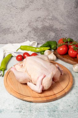 Tam tavuk. Çiğ tavuk, ahşap servis tahtasına soyulmuş. Kapat.
