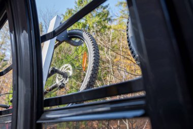 MTB bisikleti, teleferiğin açık penceresinden görülen teleferik vagonunun dışında asılı duruyor. Güzel, sonbahar, güneşli bir gün. Macera Zamanı. 