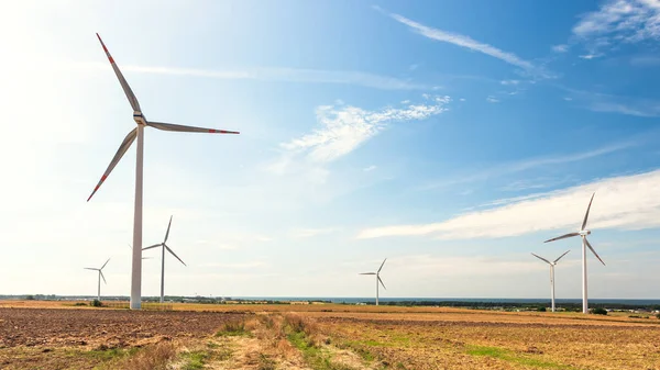 stock image Wind farm in the vicinity of agricultural fields. Windmills generating clean energy. The Baltic Sea in the distance. Darlowo, Poland