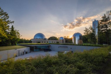 Silezya Gökevinde günbatımı. Gökyüzünü, gökyüzünü ve gözlemevi kubbelerini yansıtıyor. Çatıdaki alüminyum paneller. Chorzow, Silesian Park, Polonya