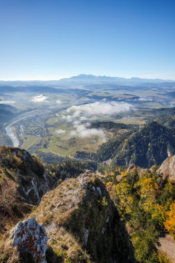 Güzel dağ manzarası. Trzy Korony zirvesinden görüntü. Uzaktaki Tatra Dağları. Dunajec Nehri Vadisi. Sonbahar manzarası. Tepelerin altındaki bulutlar. Dolambaçlı bir nehir. Sromowce Nizne, 