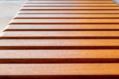 Wooden slats on the bench seat. Exotic Iroko wood. Detail. Close up clipart