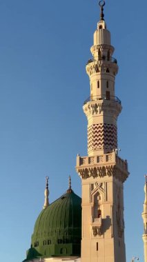 Medine, Suudi Arabistan Krallığı - 26.01.2024: Prohpet Camii 'nin yeşil kubbesi ve mamluk minaresi. Kamera sağdan sola hareket ediyor. Dikey gerçek zamanlı video.