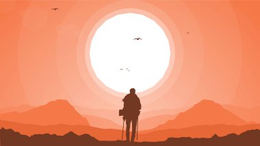 Dağcı silueti arka planı. Sırt çantalı ve bastonlu gezgin. Dağlarda bir insanın silueti. Dağlarda yürüyüş yapan bir adam.