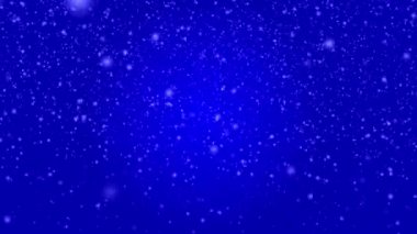 Many white snowflakes falling down on a dark blue background