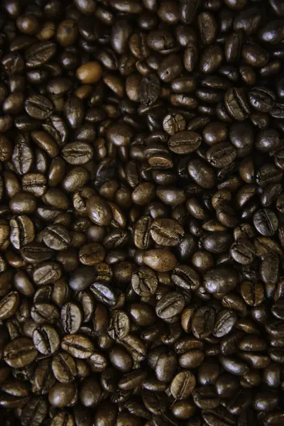 Blick Über Den Hintergrund Der Die Hälfte Der Dunkelbraunen Kaffeebohnen — Stockfoto