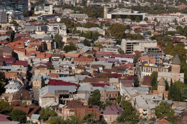 Tiflis 'in farklı ufuk çizgisine bakan manzara, geleneksel ve modern mimariyle harmanlanmış renkli çatılar dizisini yakalıyor. Canlı şehir zengin tarihini ve kültürünü yansıtıyor..