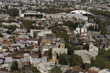 Tiflis 'in canlı şehir manzarasında yeşil zemin ve kayan tepeler karşısında tarihi binalar ve modern gelişmelerin bir karışımı yer alıyor. Bölge zengin kültür mirasını yansıtıyor..