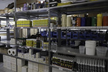 Çeşitli inşaat malzemeleri ve aletleri bir depolama tesisinin raflarında düzenli olarak düzenlenir. Malzemeler arasında boya, yapıştırıcılar ve temizlik ürünleri, organize bir çalışma alanı yaratmak,.
