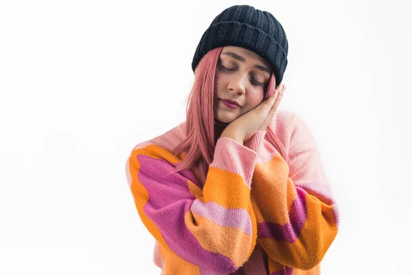 stock image medium shot of a lovely Caucasian girl with long pink hair standing with hands sealed pretending she is sleeping closed eyes, studio shot medium shot white background. High quality photo