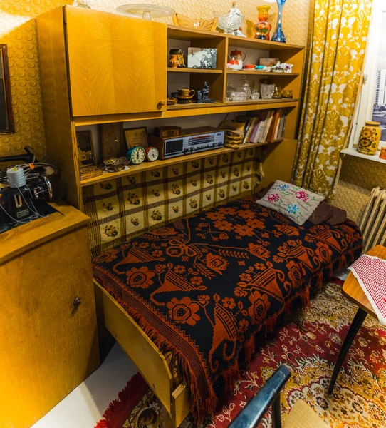 stock image Indoor shot of typical bedroom capturing the architecture and designs during PRL - The Polish Peoples Republic. Warm colors, patterns, and cosiness. Authentic bedroom items such as clocks and radio