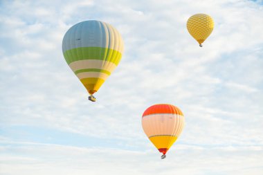 Türkiye 'nin Kapadokya üzerinde üç renkli sıcak hava balonu havada uçuşuyor. Açık parlak gündüz gökyüzü. Turist eğlencesi. Yatay çekim. Yüksek kalite fotoğraf