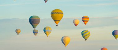 Türkiye 'nin başkenti Kapadokya' da ana turistik cazibeyi gösteren panoramik bir çekim. Hit-air balon seyahati. Mavi gökyüzü arka planında çarpıcı desenli balonlar. Yüksek kalite fotoğraf