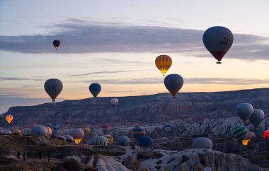 Kapadokya - Türkiye 'nin güneydoğusundaki sıcak hava balonları düzenlemesiyle ünlü kenti sabahın erken saatlerinde uçuyor. Hafif bulutlu bir gökyüzü. Turizm konsepti. Yüksek kalite fotoğraf