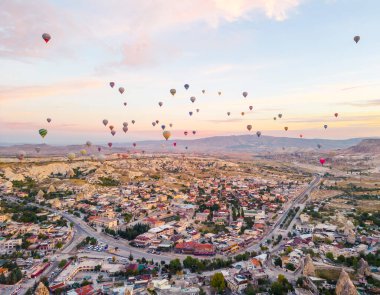 Türkiye 'nin Kapadokya kentinde sıcak hava balonu etkinliği düzenlendi. Güzel gün doğumu. Gondolda turistlerle dolu düzinelerce renkli balon var. Yüksek kalite fotoğraf