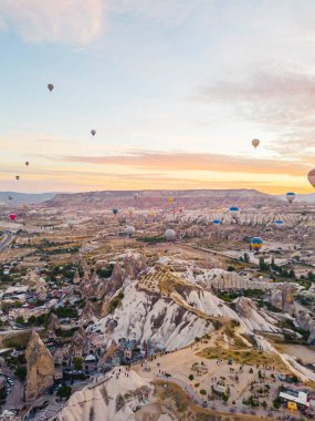 Yeraltı şehri üzerinde uçan sıcak hava balonları ve Nevsehir, Goreme, Kapadokya Türkiye 'deki peri bacaları vadisinin muhteşem insansız hava aracı görüntüsü. Yüksek kalite fotoğraf 